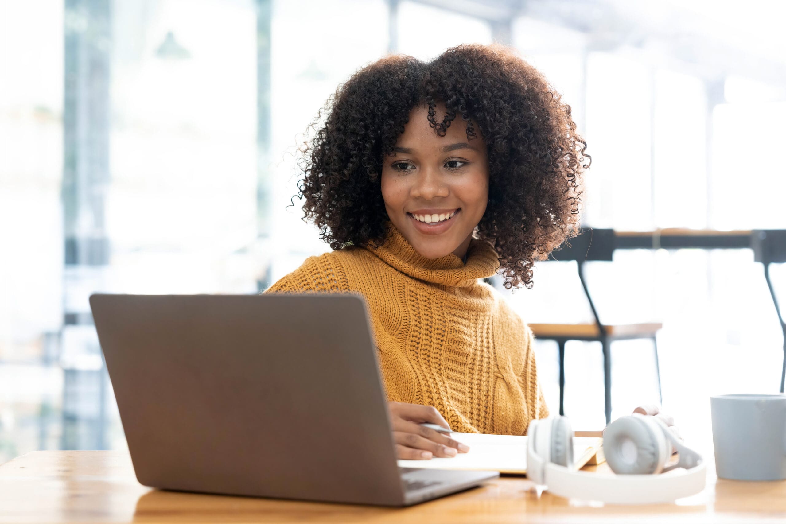 A woman searching on her laptop "How Does the Abortion Pill Work?"